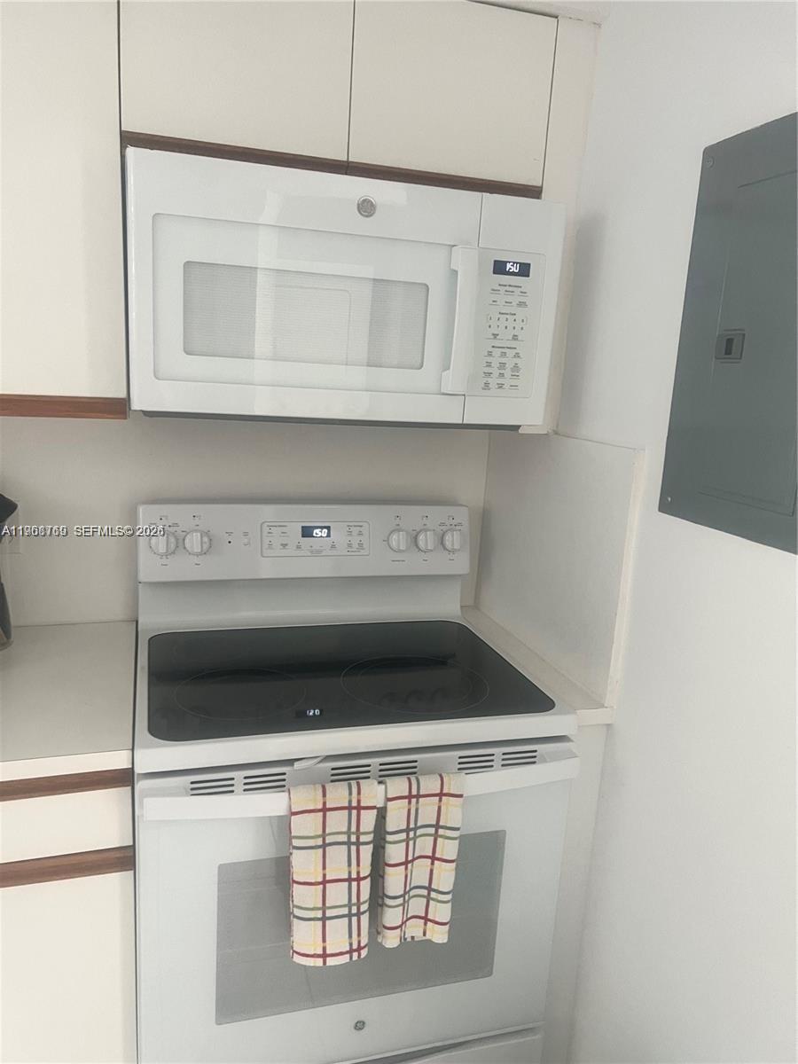 9156 Collins Avenue, Unit 204 Surfside, FL 33154 - Photo 6 of 17 a stove top oven sitting inside of a kitchen