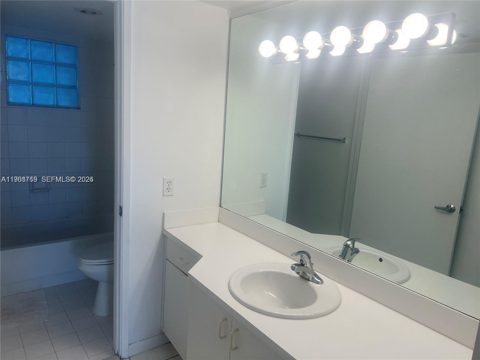 9156 Collins Avenue, Unit 204 Surfside, FL 33154 - Photo 7 of 17 a bathroom with a sink and a mirror