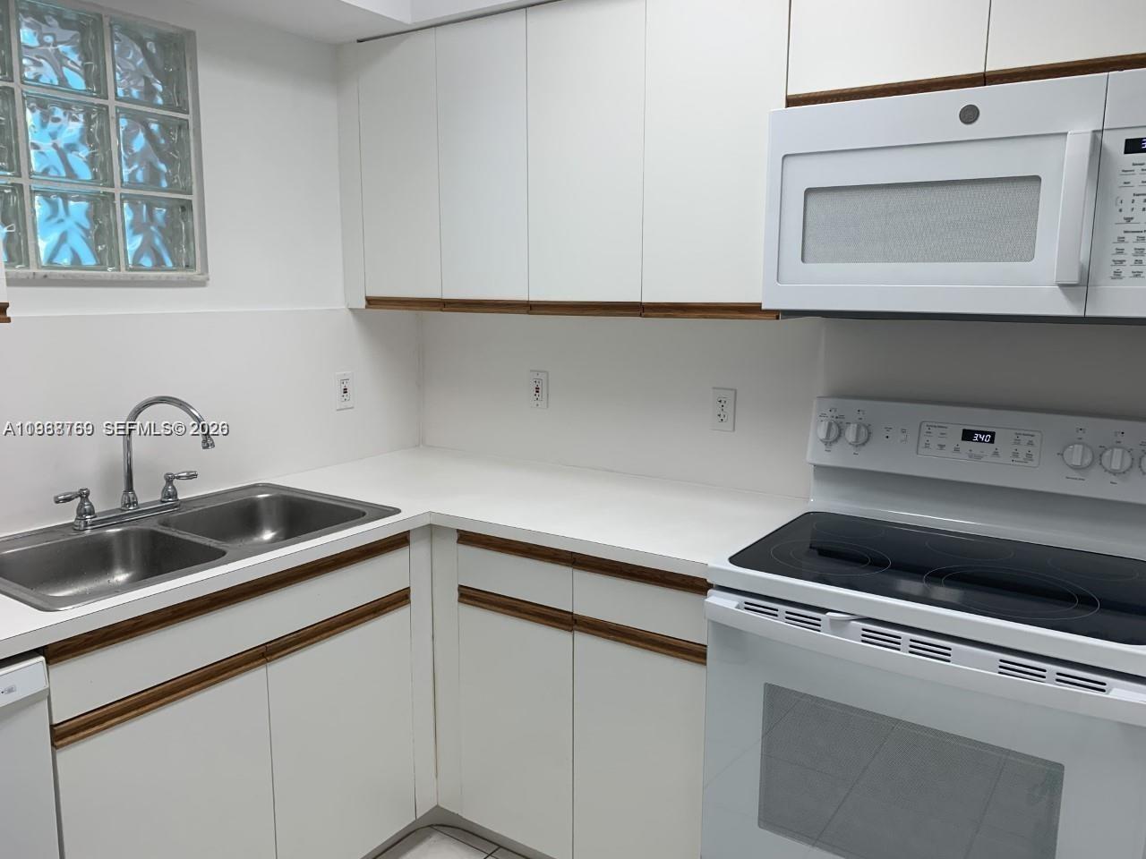9156 Collins Avenue, Unit 204 Surfside, FL 33154 - Photo 10 of 17 a kitchen with a sink and cabinets