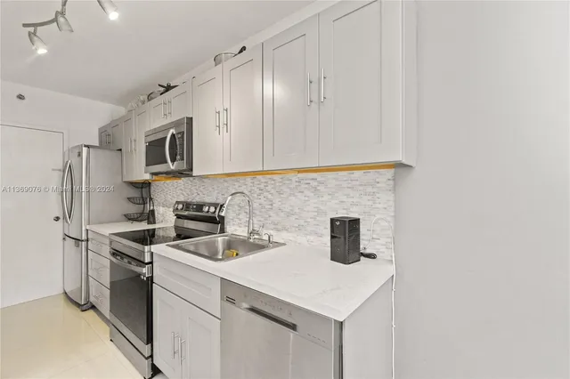 a kitchen with stainless steel appliances a sink a stove a microwave and cabinets