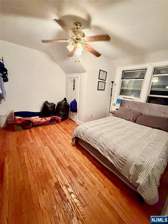 735 Elm Avenue, Unit 3E Teaneck, NJ 07666 - Photo 5 of 7 a bedroom with a large bed and a chandelier
