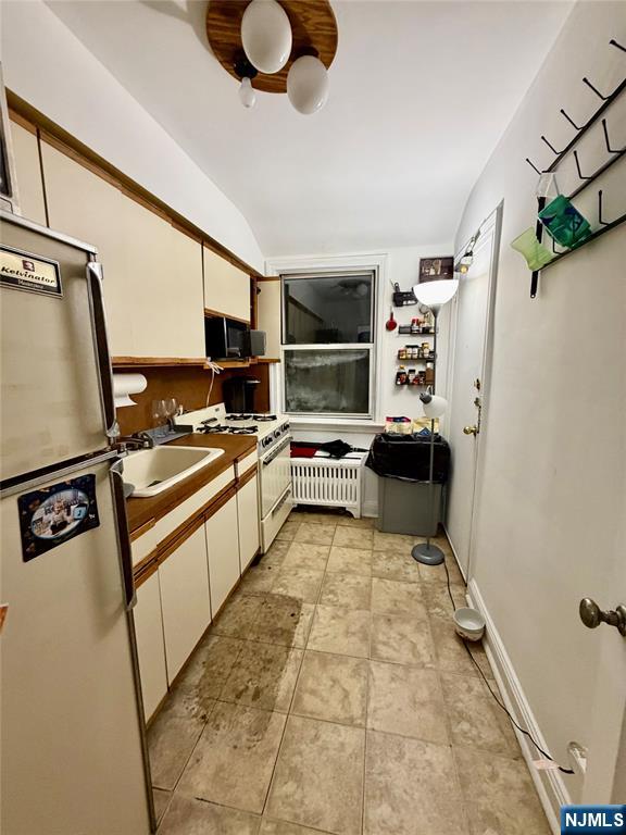 735 Elm Avenue, Unit 3E Teaneck, NJ 07666 - Photo 6 of 7 a kitchen with stainless steel appliances granite countertop a refrigerator and a stove top oven