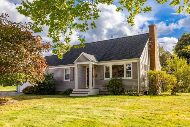 a front view of house with yard and trees around