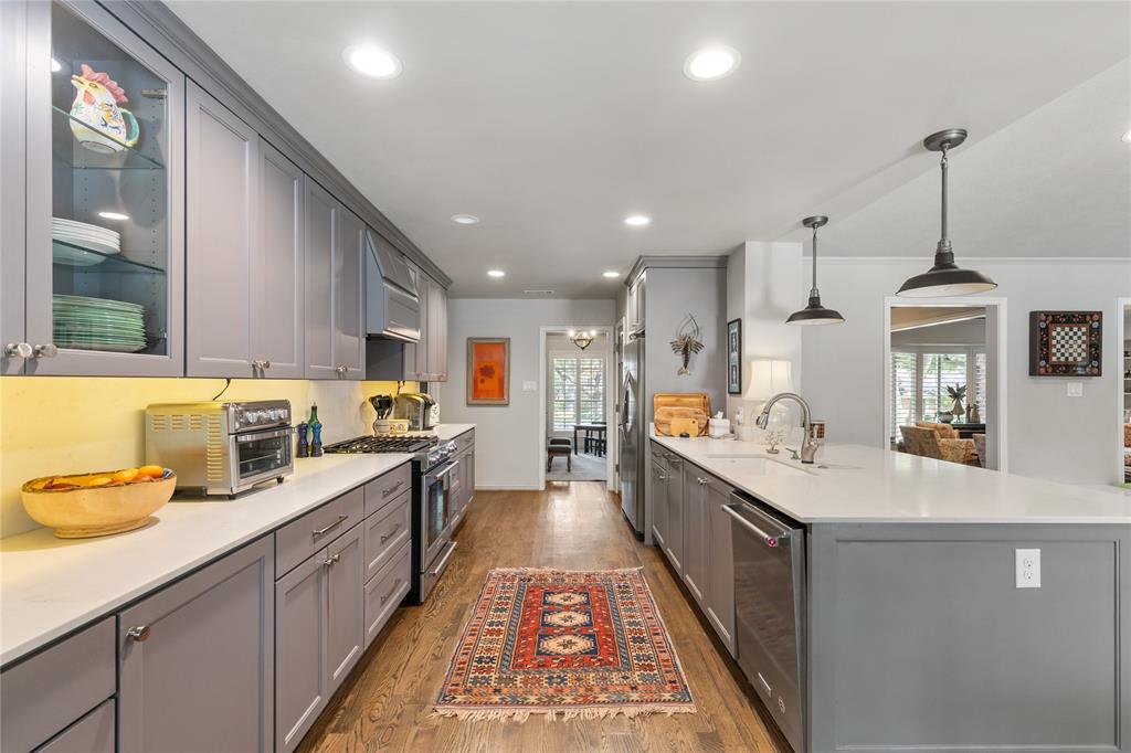 7138 Grand Oaks Road Dallas, TX 75230 - Photo 16 of 39 a large kitchen with stainless steel appliances lots of counter space and a sink