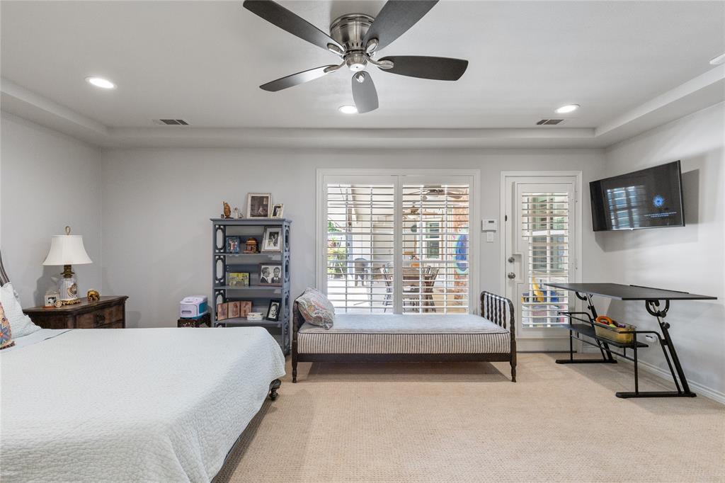 7138 Grand Oaks Road Dallas, TX 75230 - Photo 19 of 39 a bed room with a bed a furniture and a flat screen tv