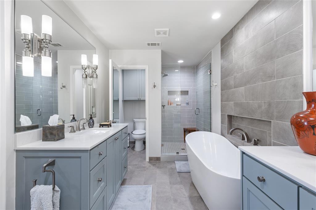 7138 Grand Oaks Road Dallas, TX 75230 - Photo 21 of 39 a bathroom with a double vanity sink a toilet a mirror and shower