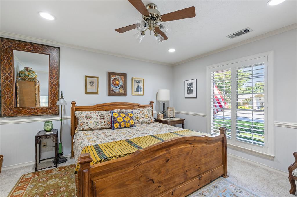 7138 Grand Oaks Road Dallas, TX 75230 - Photo 23 of 39 a bedroom with a large bed and a chandelier