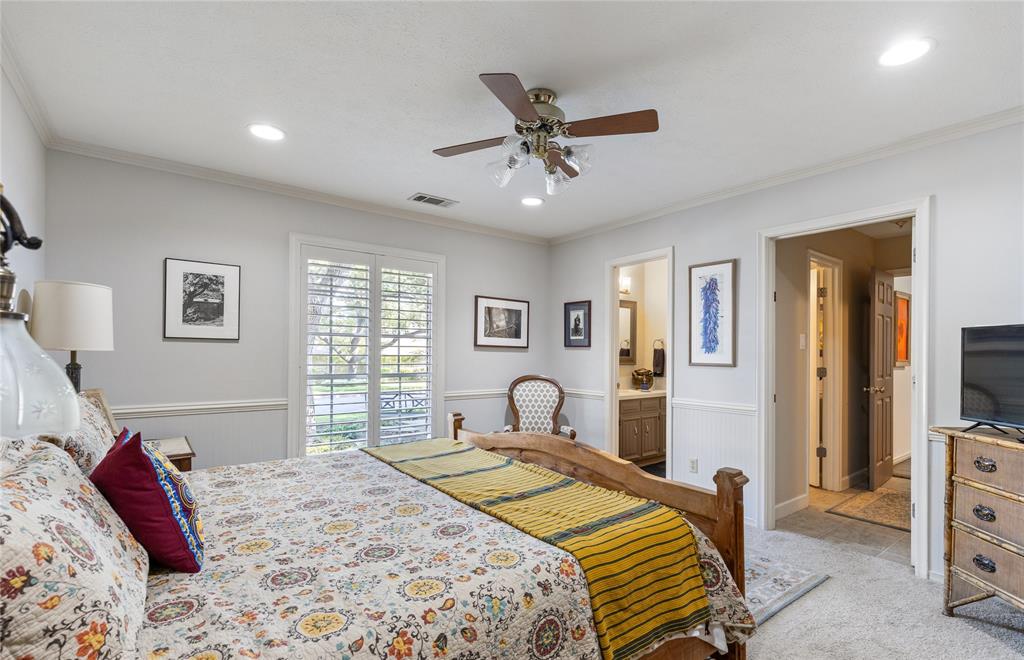 7138 Grand Oaks Road Dallas, TX 75230 - Photo 24 of 39 a bedroom with a bed and a flat screen tv