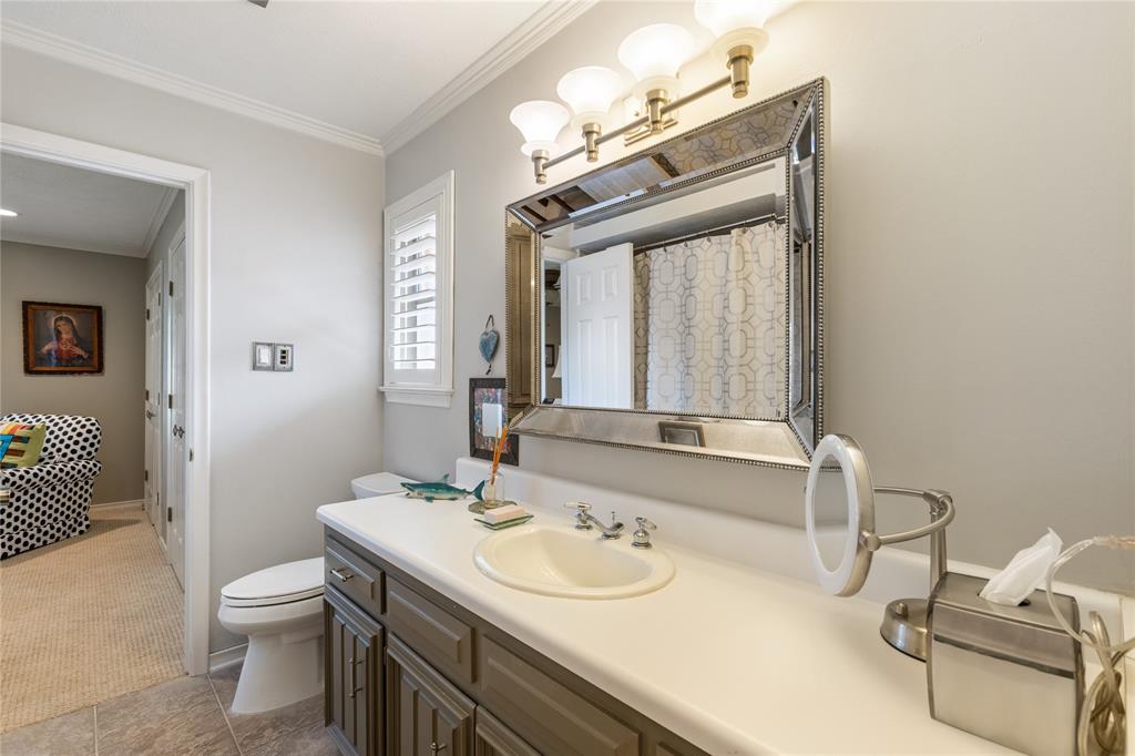 7138 Grand Oaks Road Dallas, TX 75230 - Photo 28 of 39 a bathroom with a sink and a mirror