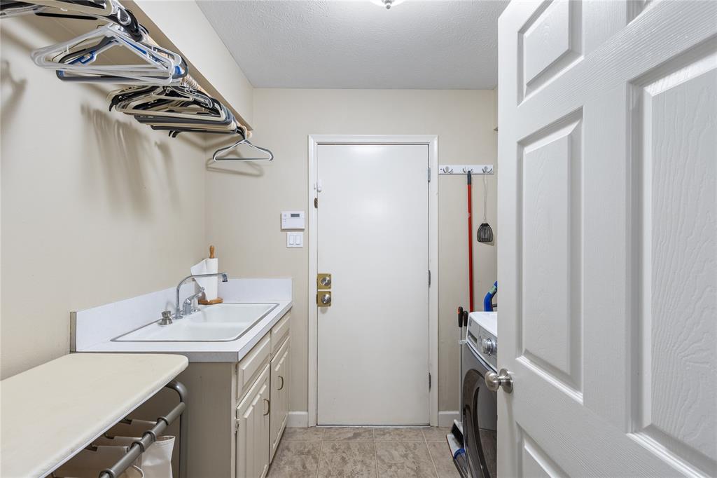 7138 Grand Oaks Road Dallas, TX 75230 - Photo 29 of 39 a bathroom with a sink a washer and dryer