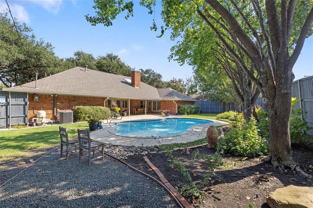 7138 Grand Oaks Road Dallas, TX 75230 - Photo 35 of 39 a table and chairs under an umbrella in backyard