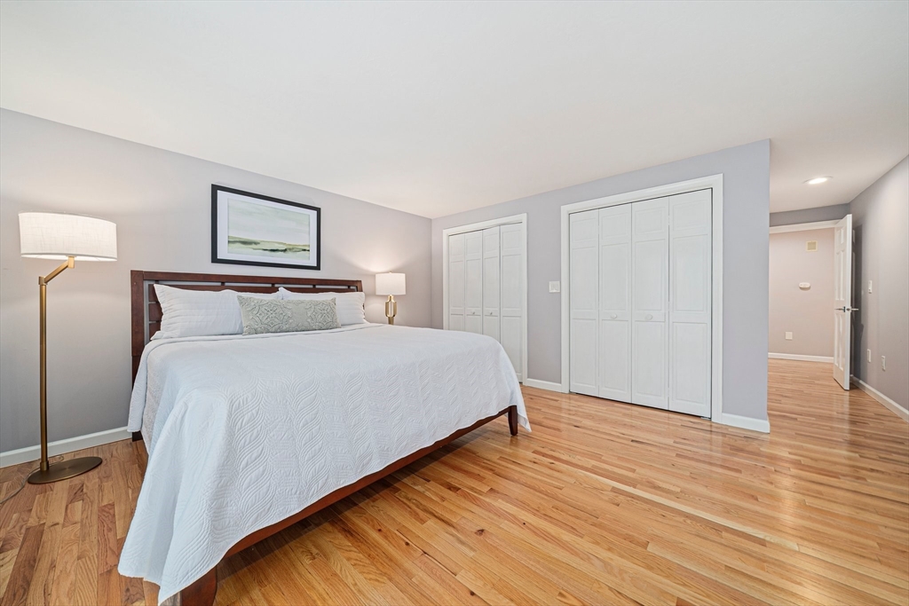 9 Powder Hill Way, Unit 9 Westborough, MA 01581 - Photo 12 of 40 a bedroom with a bed and wooden floor