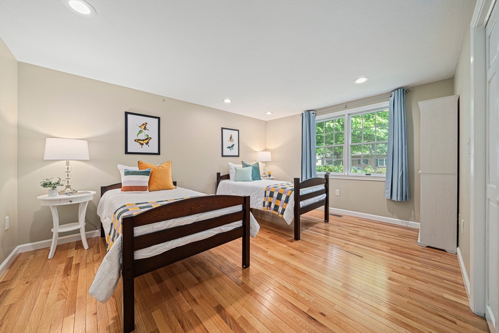 9 Powder Hill Way, Unit 9 Westborough, MA 01581 - Photo 13 of 40 a bedroom with a bed a large window with wooden floor