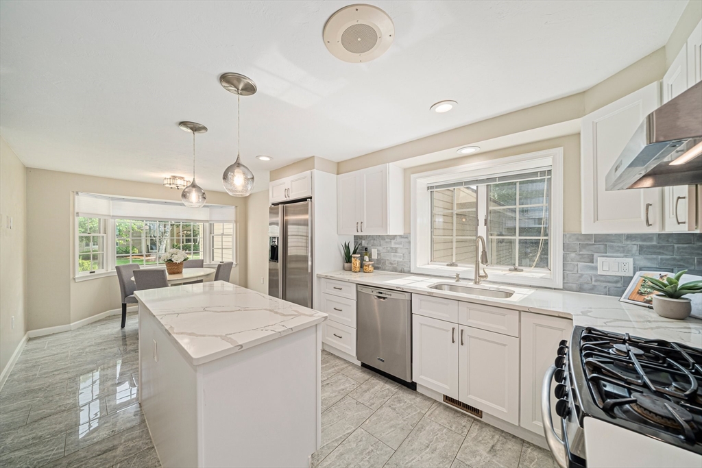 9 Powder Hill Way, Unit 9 Westborough, MA 01581 - Photo 2 of 40 a large kitchen with kitchen island a sink stove and white cabinets