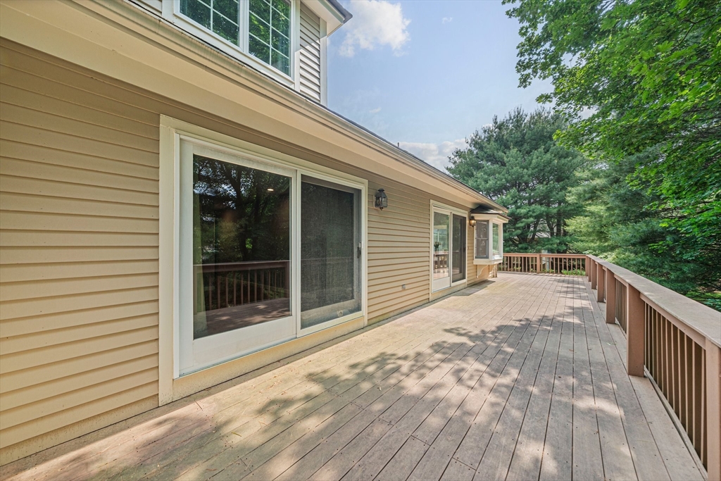 9 Powder Hill Way, Unit 9 Westborough, MA 01581 - Photo 31 of 40 a view of backyard with large trees and wooden fence