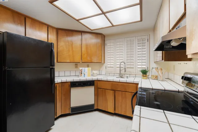 a kitchen with a sink a refrigerator and cabinets