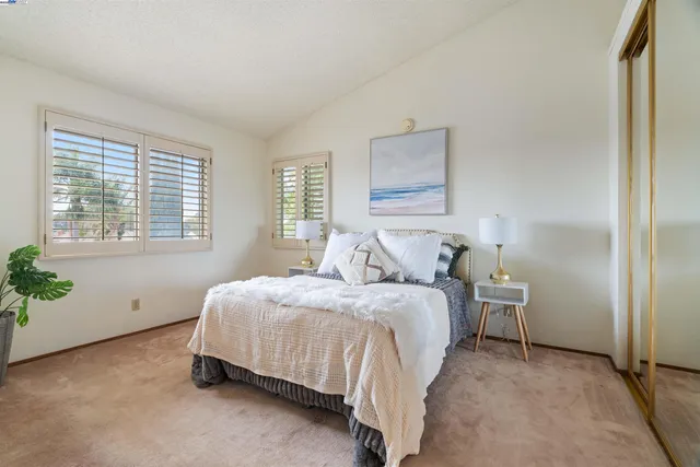 a bedroom with a bed lamp and a window