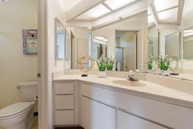 a bathroom with a sink and mirror with toilet