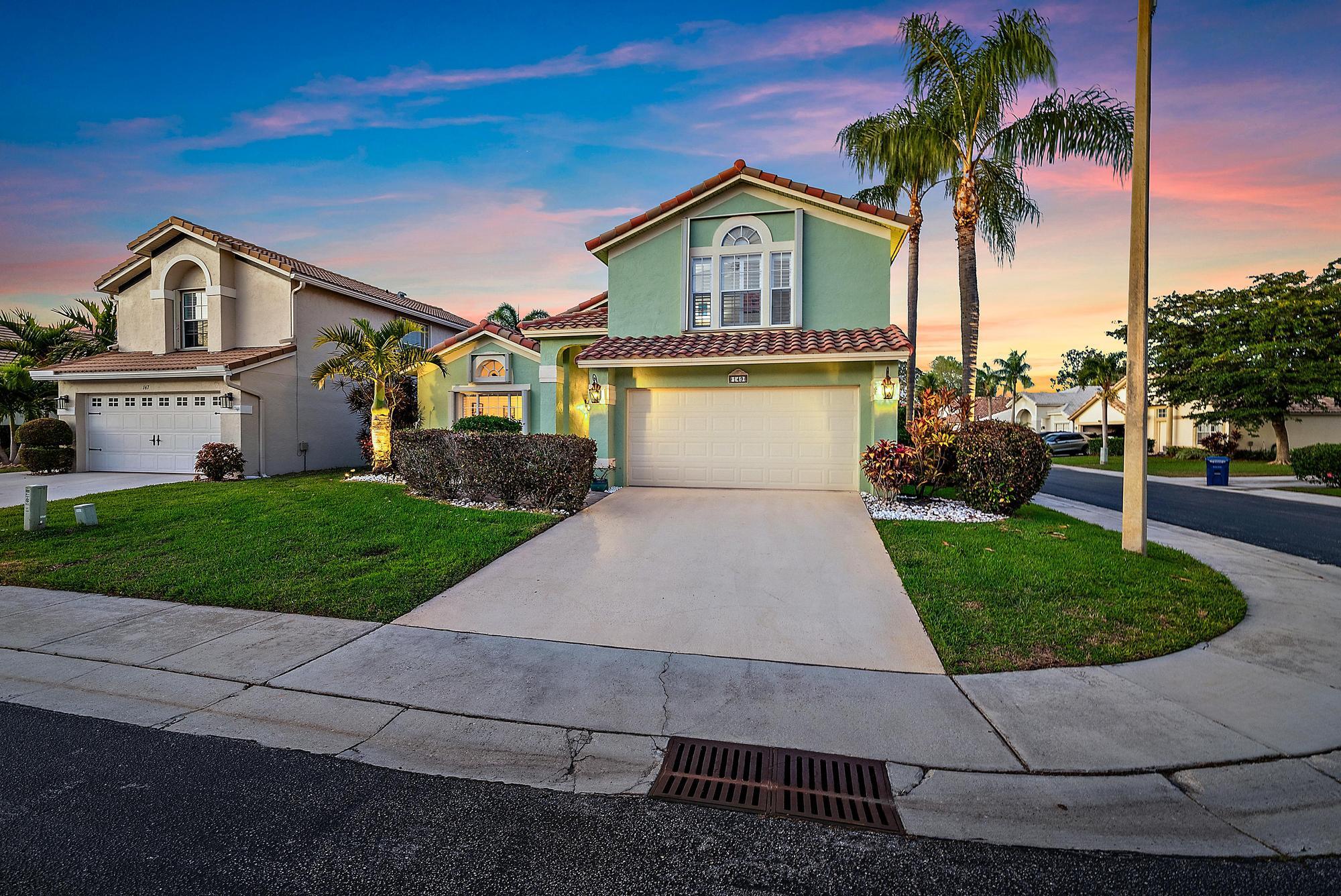 149 Stonebriar Boulevard Jupiter, FL 33458 - Photo 1 of 42 a front view of a house with a yard and garage