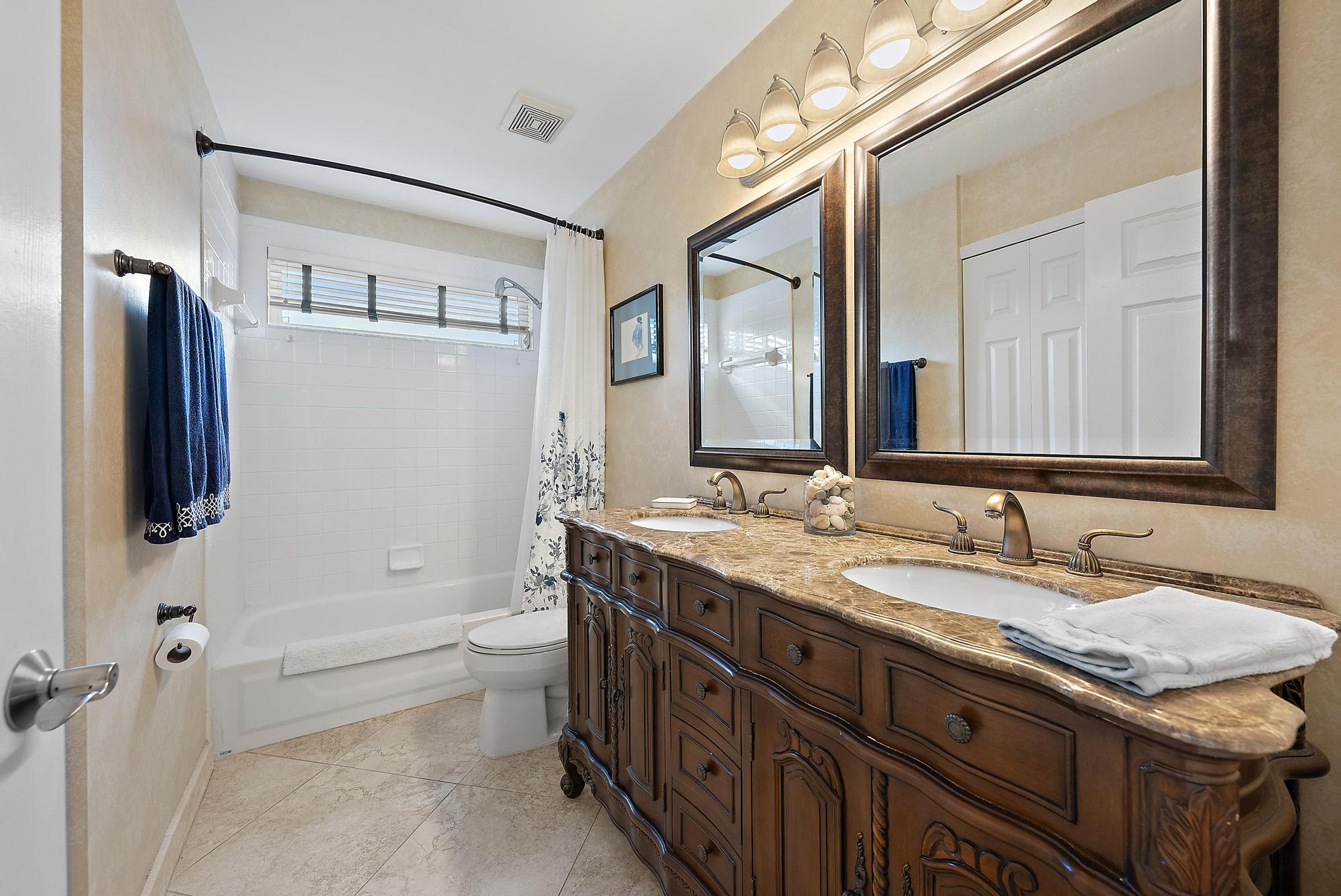 149 Stonebriar Boulevard Jupiter, FL 33458 - Photo 24 of 42 a bathroom with a granite countertop sink a toilet a mirror and shower