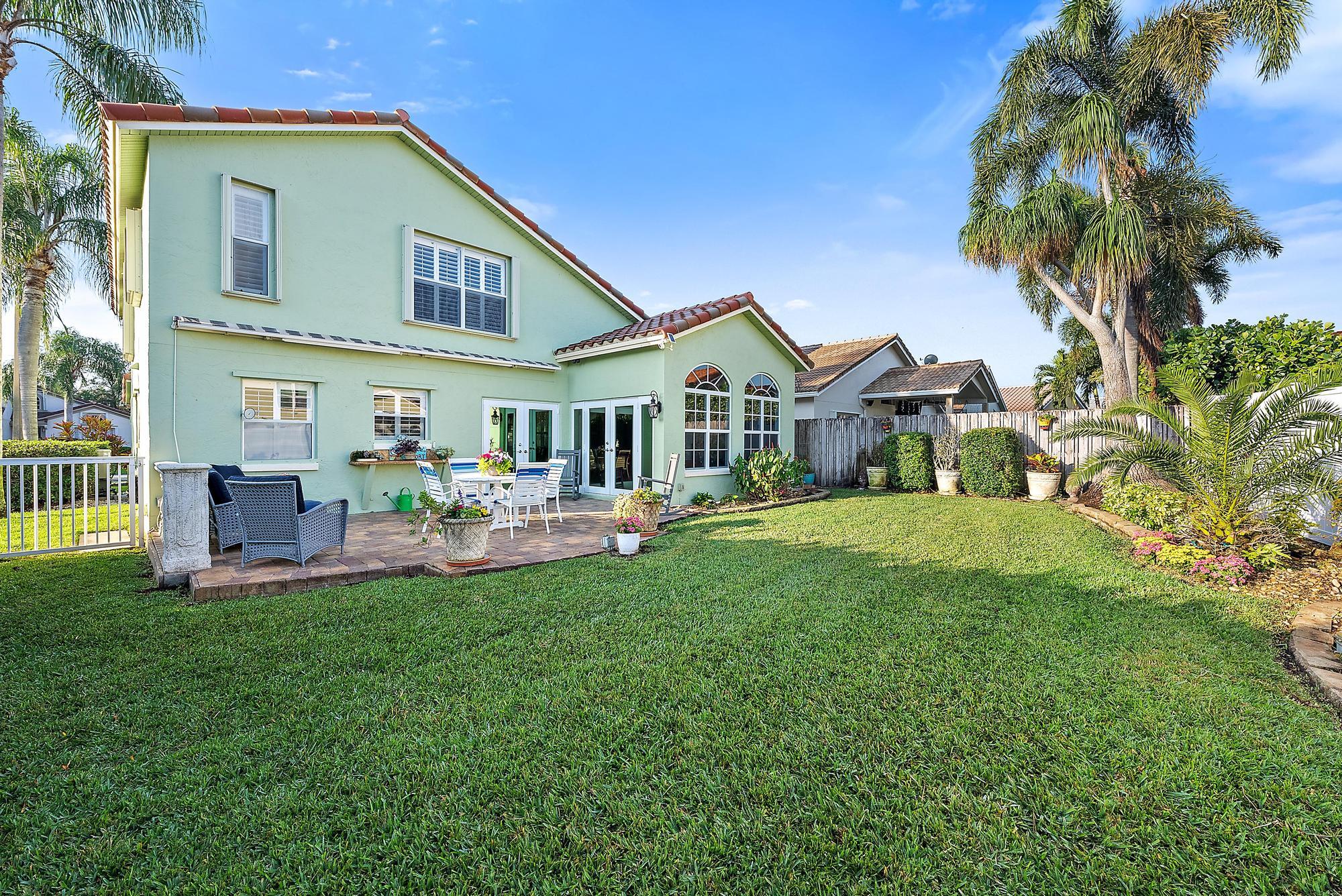 149 Stonebriar Boulevard Jupiter, FL 33458 - Photo 37 of 42 a front view of a house with a yard table and chairs