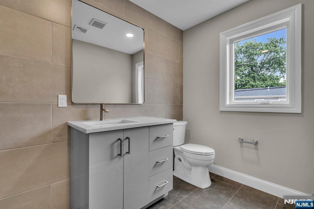 55 Maiden Lane Bergenfield, NJ 07621 - Photo 39 of 49 a bathroom with a toilet sink and mirror
