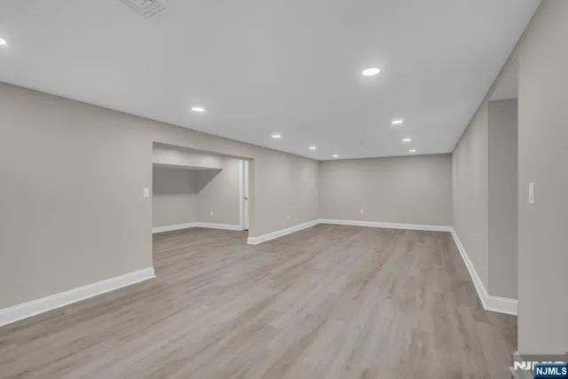 a view of an empty room with wooden floor and closet
