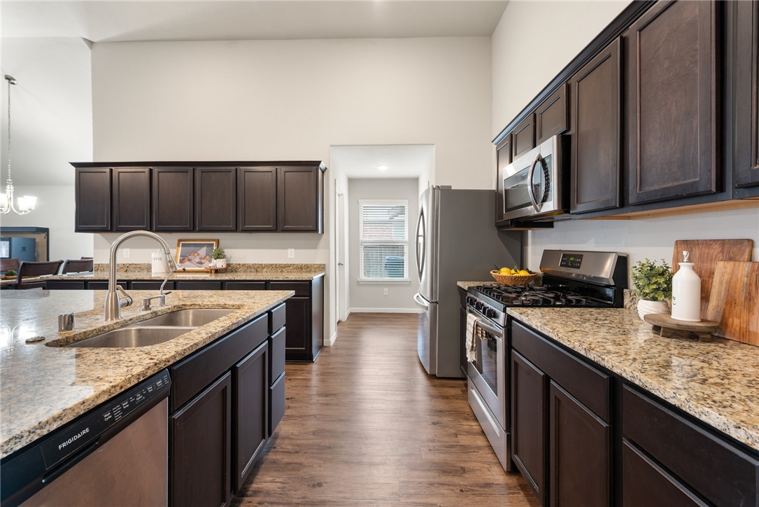 2018 Eagle View Drive Navasota, TX 77868 - Photo 7 of 28 a kitchen with stainless steel appliances granite countertop a stove a sink dishwasher and a refrigerator with wooden cabinets