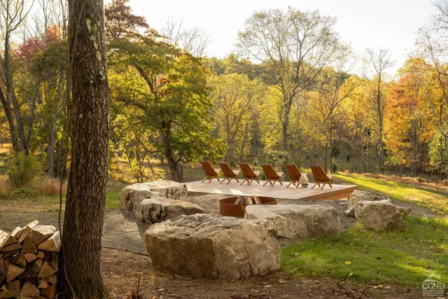 a view of a white house with a big yard and large trees