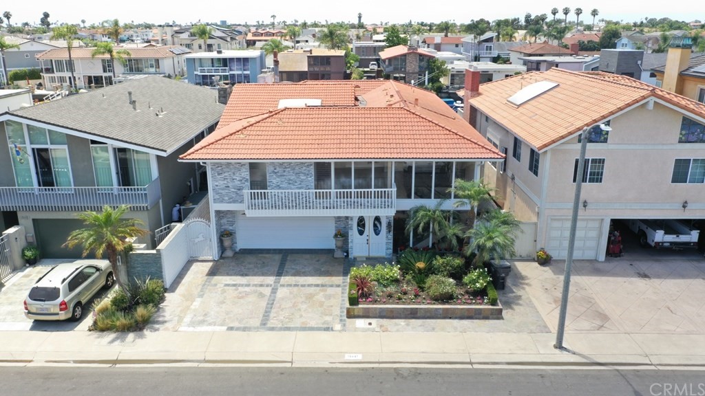 a view of a white house with a bench and lawn chairs