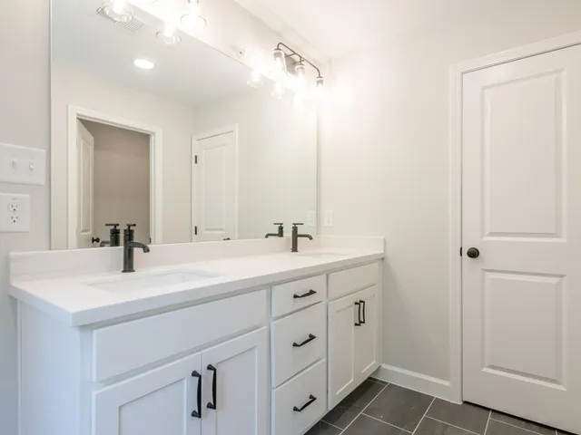 a bathroom with a double vanity sink and mirror