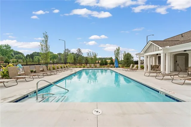 an outdoor view of house with swimming pool and lounge chair