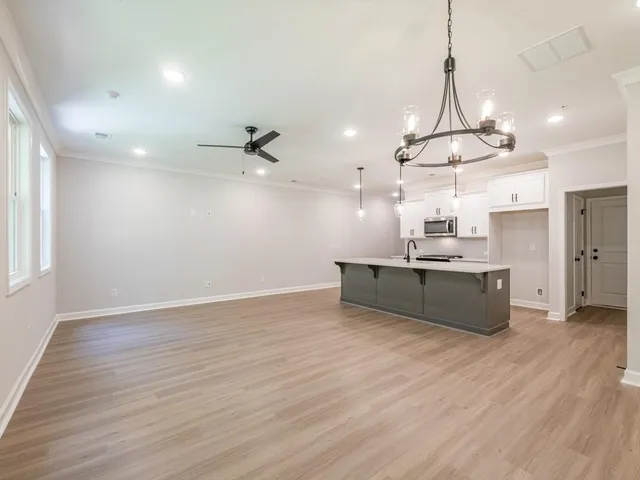 a large kitchen with a lot of cabinets and wooden floor