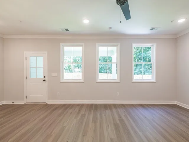 an empty room with wooden floor and windows