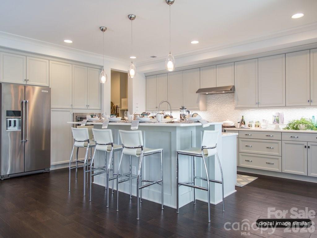 2008 Thatcher Way Fort Mill, SC 29715 - Photo 9 of 27 a kitchen with stainless steel appliances kitchen island granite countertop a stove a refrigerator and white cabinets with wooden floors
