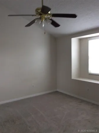 en empty room with windows and fan