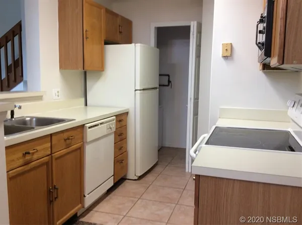 a kitchen with a refrigerator sink and cabinets
