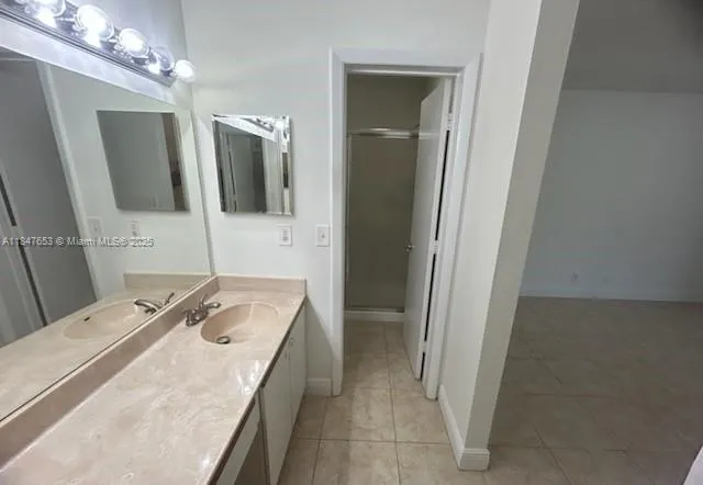 a bathroom with a sink a large mirror and a shower