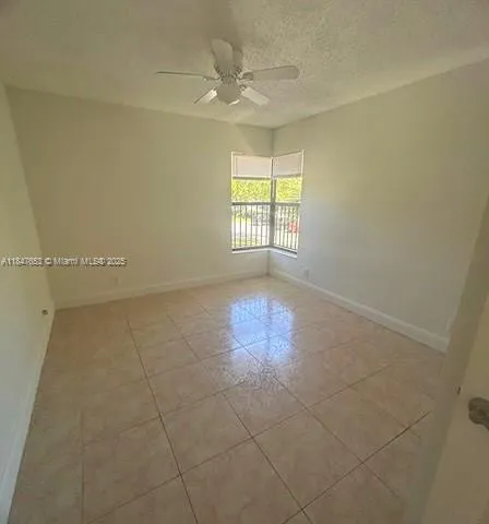 en empty room with windows and ceiling fan