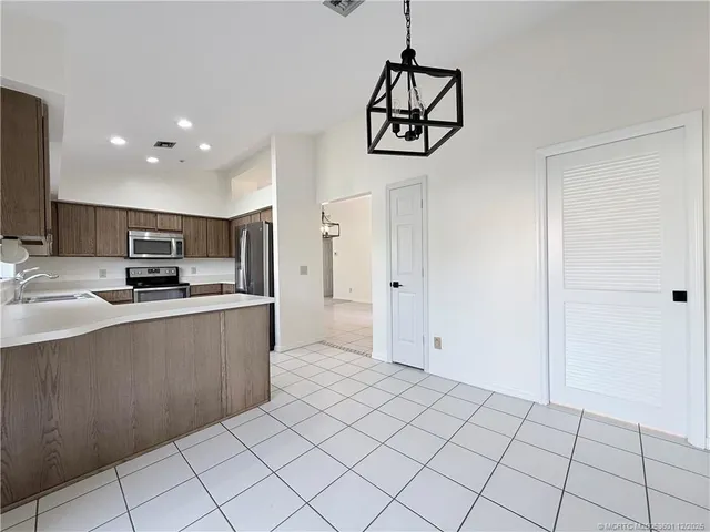 a kitchen with kitchen island granite countertop appliances cabinets and a sink