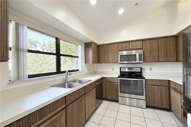 a kitchen with stainless steel appliances granite countertop a sink a stove a microwave and cabinets