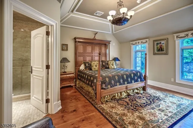 a bedroom with a large bed and a chandelier