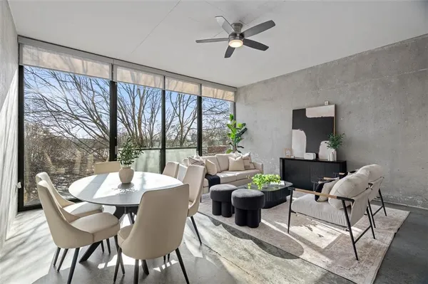 a dining room with furniture a large window and a chandelier