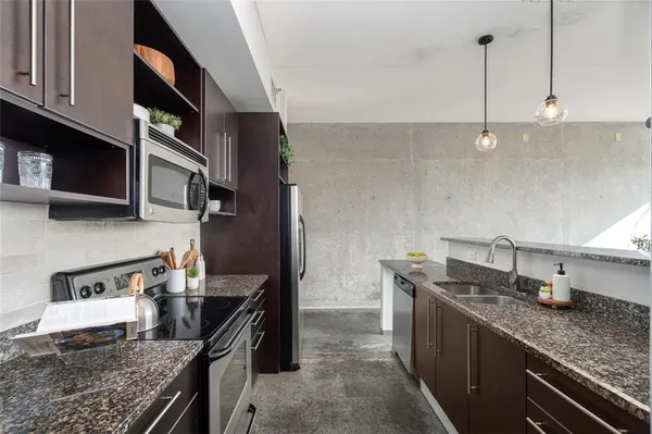 a kitchen with stainless steel appliances granite countertop a refrigerator and a stove