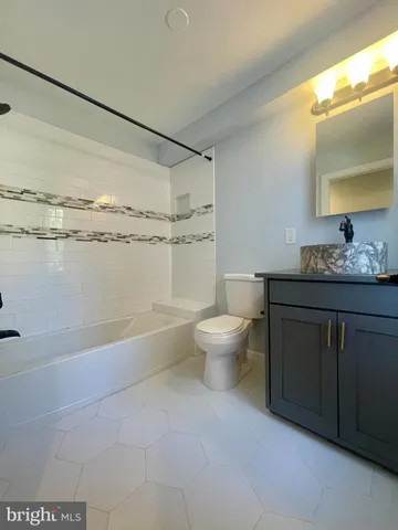 a bathroom with a granite countertop sink a toilet and bathtub