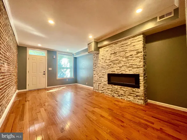 a view of empty room with wooden floor and fireplace