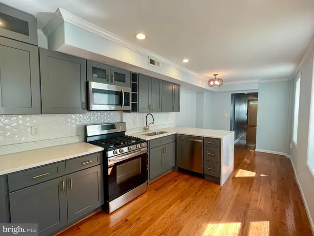 a kitchen with granite countertop a stove top oven and cabinets