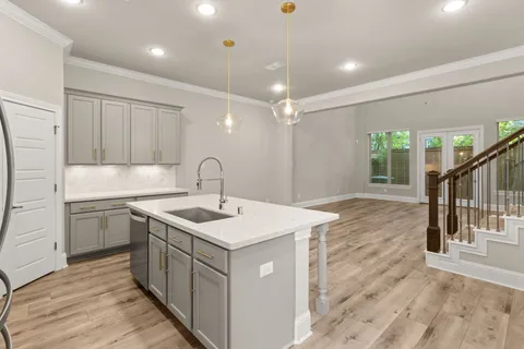a kitchen with kitchen island a sink appliances and cabinets