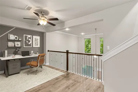 a view of a room with wooden floor and a ceiling fan