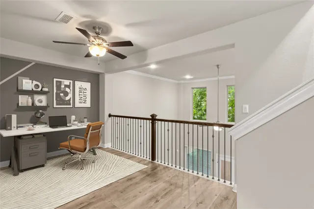 a view of a room with wooden floor and a ceiling fan